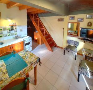 a kitchen with a table and a staircase in a room at Cabañas Tunquelen in El Bolsón
