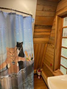 two cats sitting on a shower curtain in a bathroom at Shannaghs Sweet Escape in Powell River +65 photos