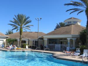 a pool at a resort with people laying on chairs at Vacation Fantasia - Mins to Disney - Pool & Hot Tub in Kissimmee