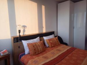 - une chambre avec un lit doté d'oreillers et d'une lampe dans l'établissement Vue imprenable sur Paris, à Paris