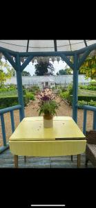 a yellow table with a potted plant on a gazebo at The Railway Carriage - Blue in Glasbury +4 photos