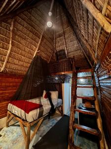 a bedroom with a hammock in a straw hut at Valle Bucana in Santa Bárbara de Samaná