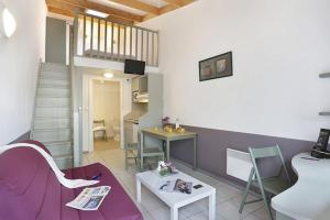 Una sala de estar con un sofá morado y una mesa. en BNB TOULOUSE - Le Petit Mervillois - Clim - Parking - WiFi, en Merville