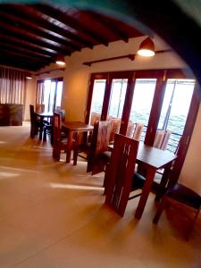 een eetkamer met tafels en stoelen en ramen bij Transit Studio Katunayake in Katunayaka