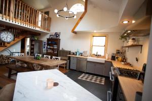 a large kitchen with a table and a clock at Cheerful 3-bedroom cabin with mountain view in East Jewett