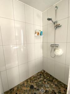 a bathroom with a shower with a tile floor at De bric et de broc , maison à 100m plage in Asnelles