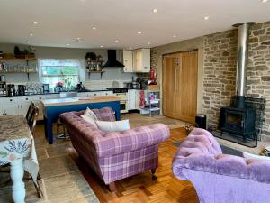 a living room with two couches and a kitchen at Cuthbert Hill Farm in Preston