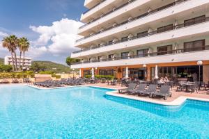 Una piscina de hotel con sillas y un edificio. en Tropic Park, en Malgrat de Mar