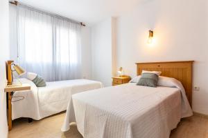a bedroom with two beds and a window at Apartamento Paquita R&R in Aguadulce