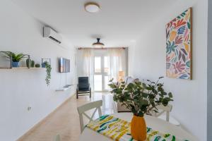 a dining room with a table with a vase on it at Apartamento Paquita R&R in Aguadulce