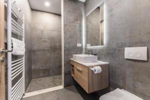 a bathroom with a sink and a toilet and a mirror at KOA - Aparthotel in Braşov +139 photos