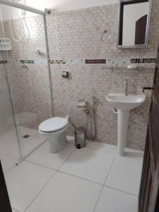a bathroom with a toilet and a sink at Casa Grande com 3 suítes in Peruíbe