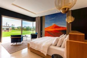 a bedroom with a large bed with a painting on the wall at Villa des stars in Marrakesh +22 photos