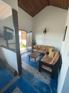 a living room with a couch and a table at Casa Grande com 3 suítes in Peruíbe