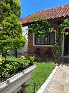 a house with a garden with two benches in the yard at Casa Grande com 3 suítes in Peruíbe +36 photos
