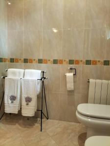 a bathroom with white towels and a toilet at A casa do castaño in Nigrán