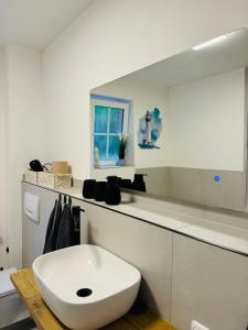 a white bathroom with a sink and a mirror at Charmante Ferienwohnung in Scharbeutz -Ihr perfektes Zuhause am Meer! Terasse, Parken & Strand! W1 in Scharbeutz