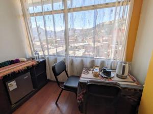 a room with a table and a large window at Monoestudio Sicuani in Sicuani