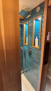 a bathroom with a shower with blue tile at City Hideaway, Off Grid Luxe in Lancaster +23 photos