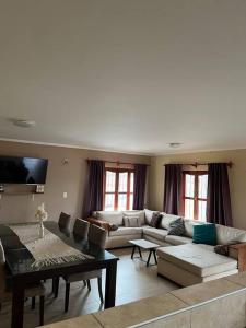 un soggiorno con un divano e un tavolo di Salta Casa El rodeo a Salta