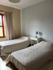 una camera da letto con due letti, un tavolo e una finestra di Salta Casa El rodeo a Salta Altre 12 foto