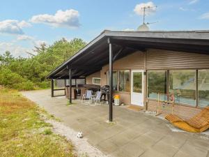 a house with a patio with chairs on it at Dune Escape with Games and WiFi-By Traum in Bjerregård