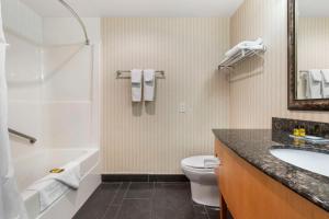 La salle de bains est pourvue d'une baignoire, de toilettes et d'un lavabo. dans l'établissement Best Western Plus Kelowna Hotel & Suites, à Kelowna