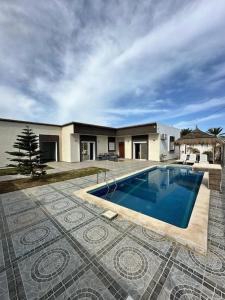 ein Swimmingpool vor einem Haus in der Unterkunft Villa au cœur de l'île in Taguermess
