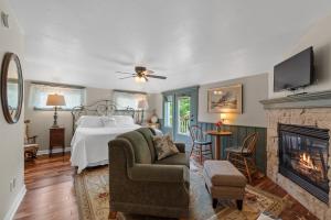 a living room with a bed and a fireplace at The Foxglove Inn in Sturgeon Bay