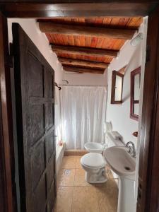 a bathroom with a white toilet and a sink at Hostal Tierra Andina Cafayate in Cafayate