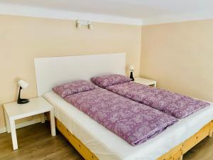 a bed with a purple comforter in a bedroom at Pink Rose Boutiques in Budapest