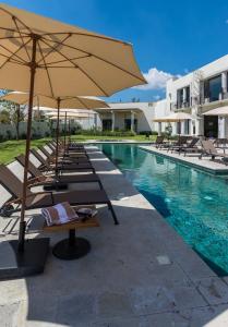 サンミゲル・デ・アジェンデにあるDeluxe Design Condo, San Miguelのラウンジチェアとパラソル付きのスイミングプールを併設しています。