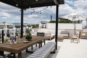 サンミゲル・デ・アジェンデにあるDeluxe Design Condo, San Miguelの木製テーブルと屋根のベンチ付きのパティオ