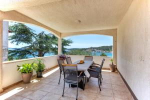 a patio with a table and chairs on a balcony at Apartments by the sea Tisno, Murter - 812 in Tisno