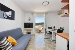 a living room with a blue couch and a table at Apartments by the sea Tisno, Murter - 812 in Tisno