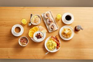 a table with plates of breakfast foods and cups of coffee at Holiday Inn Express & Suites Naples Downtown - 5th Avenue by IHG in Naples