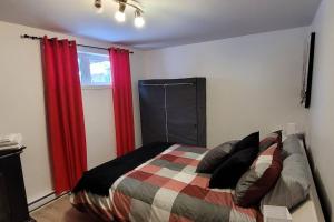 ein Schlafzimmer mit einem Bett mit roten Vorhängen und einem Fenster in der Unterkunft Le Repaire Secret in Saint-Donat-de-Montcalm