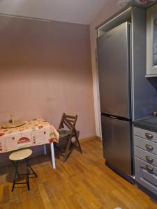 Una pequeña cocina con una mesa y un refrigerador. en Сocon bien douillet, en Saint-Denis-dʼOléron