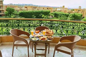 a table with food and drinks on a balcony at Luca Pyramids Inn in Cairo