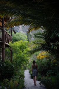 a woman walking down a path in a garden at Andean Wings Valley in Urubamba
