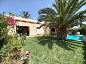 a house with a palm tree and a swimming pool at Luxueuse villa Proche Agadir et Taroudant pour 6 pers Piscine Privée sans vis à vis in Agadir