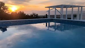 una piscina con un tramonto sullo sfondo di Seaside house with a swimming pool Prigradica, Korcula - 22904 a Blato Altre 11 foto