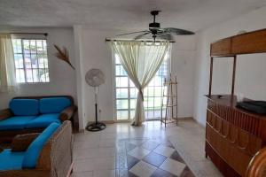a living room with a blue couch and a window at Lugar auténtico para vacacionar in La Sabana