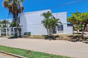 a white building with palm trees in front of it at Lugar auténtico para vacacionar in La Sabana +13 photos