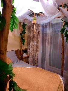 a bedroom with a bed and a window with curtains at La Cornée Renard in Saint-Dizier