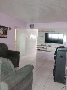 ein Wohnzimmer mit Couch und Flachbildfernseher in der Unterkunft Casa para festival de inverno Garanhuns in Garanhuns