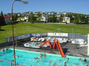 a swimming pool with people playing in the water at Vetursetur in Laxamýri