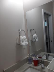 a bathroom with a sink and a mirror with towels at PineOrange Home in Saskatoon +6 photos