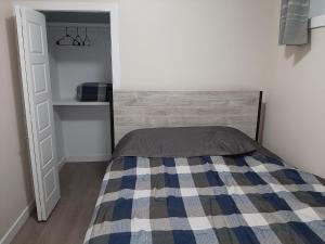 a bedroom with a bed with a checkered blanket at PineOrange Home in Saskatoon