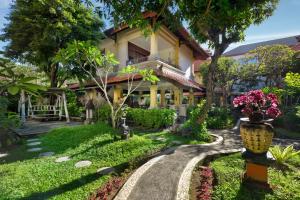 a walkway in front of a house with flowers at Villa at Royal Tunjung Bali in Seminyak